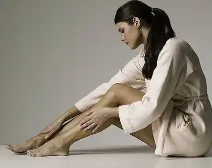 WOMAN RUBBING LEGS